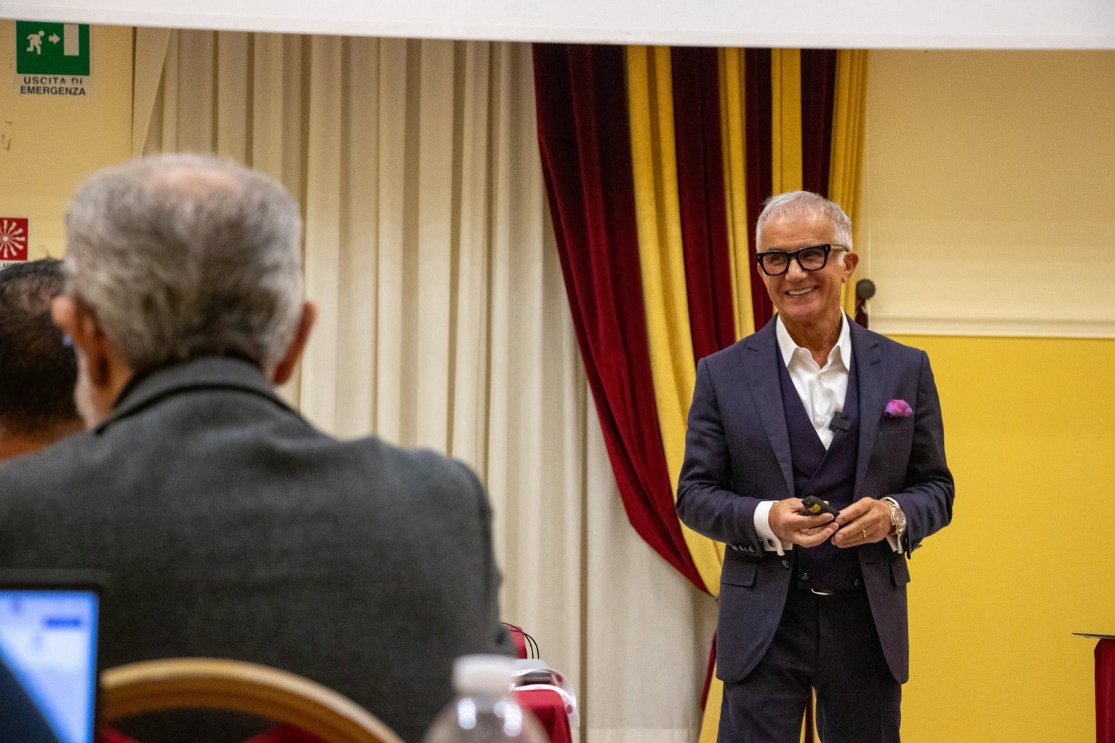 Un relatore sorride al pubblico durante un evento OSM